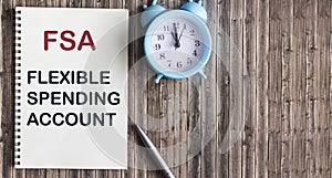 FSA flexible expense account sign on notepad and wooden background