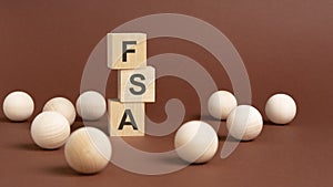FSA - Flexible Spending Account - letter pices on the wooden cubes, brown background photo