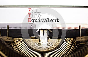 FTE Full time equivalent symbol. Concept words FTE Full time equivalent typed on beautiful retro old typewriter. Beautiful white