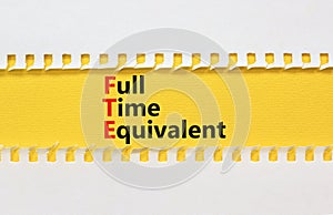 FTE Full time equivalent symbol. Concept words FTE Full time equivalent on yellow paper. Beautiful white table white background.