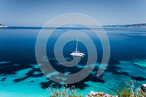 Fteri beach, Cephalonia Kefalonia, Greece. White catamaran yacht in clear blue transparent sea water surface photo