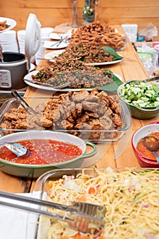 Fucusing on the pile of Thai fried fish paste meat balls in glass triangle dish and the others Thai food beside and around it. All