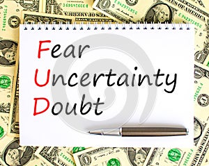 FUD fear uncertainty doubt symbol. Concept words FUD fear uncertainty doubt on white note on a beautiful background from dollar