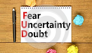 FUD fear uncertainty doubt symbol. Concept words FUD fear uncertainty doubt on white note on a beautiful wooden background.