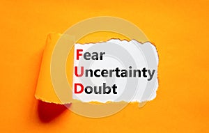 FUD fear uncertainty doubt symbol. Concept words FUD fear uncertainty doubt on white paper on a beautiful orange background.