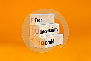 FUD fear uncertainty doubt symbol. Concept words FUD fear uncertainty doubt on wooden blocks on a beautiful orange table orange