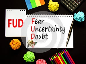 FUD fear uncertainty doubt symbol. Concept words FUD fear uncertainty doubt on white note on a beautiful black background.