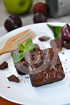 Fudge Brownies on Plate with Fruits on Background