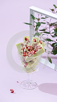 Fudge, sweet candies, handmade dessert made of white chocolate, matcha tea and strawberries on a bright background.