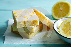 Fudgy lemon brownies with lemon glaze on an aquamarine background photo