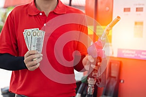 Fuel cost saving concept, staff worker hand holding money cash back at Gas station