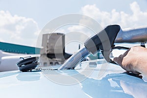 Fuel nozzle filling up aircraft, refueling jet fuel in an aircraft wing, Focused on refueling gun. Focused on refueling gun