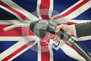 Fuel pump nozzle in hand with national flag on background - United Kingdom - UK - Great Britain