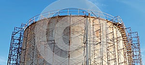 the fuel stock tank install steel scaffolding repair outdoor color against blue sky