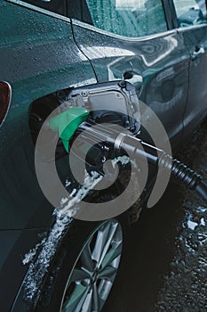 In the fuel tank of a car, a gas pump nozzle. winter season