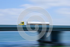 Fuel tanker semi truck on bridge with motion blur