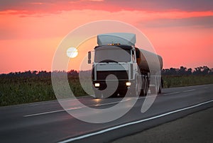 Fuel truck goes on highway on sunset