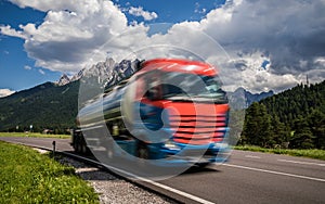 Fuel truck rushes down the highway in the background the Alps. Truck Car in motion blur