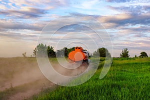 A fuel truck rushing along a dirt road leaving behind clouds of dust