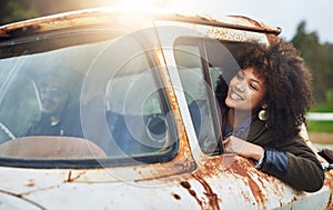 Fueled by imagination. a happy young woman sitting in a rusty old truck.