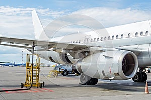Fueling aircraft, view of the wing, hose, engine. Airport Service.