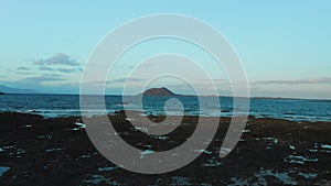 Fuerteventura. Canary Islands. Aerial view from volcanic rocky beach on Isla De Lobos. Sunset in summer day. Moody. Dusk