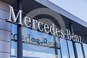 Mercedes-Benz logo hangs on a car dealer building