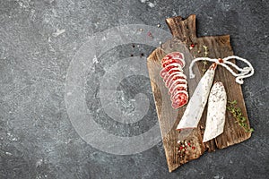 Fuet Salami. Traditional Spanish sausage cut in slices on a wooden board on a dark background. banner, menu, recipe place for text