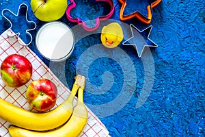 Fuit snack for clildren. Fruits and milk on blue table background top view copyspace