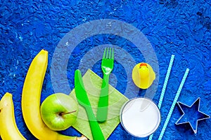 Fuit snack for clildren. Fruits and milk on blue table background top view copyspace