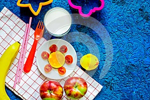 Fuit snack for clildren. Fruits and milk on blue table background top view copyspace