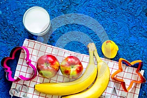 Fuit snack for clildren. Fruits and milk on blue table background top view copyspace