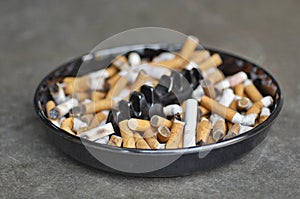 Full ashtray of cigarettes on table, close-up