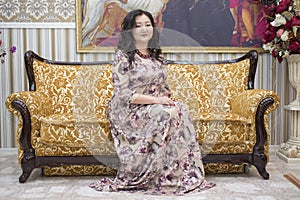 A full Asian woman sitting on the sofa in the living room.