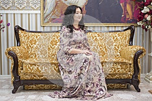 A full Asian woman sitting on the sofa in the living room.
