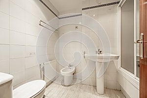 A full bathroom with showers with screens, white porcelain toilets