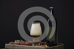 Full beer glass with foam and bottle