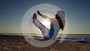 Full boat yoga pose on beach