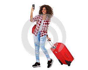 Full body attractive young african american girl walking with suitcase and taking selfie