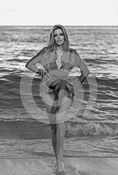 Full body of beautiful sexy woman with long legs in sea waves. Beautiful girl enjoying sunbath at beach. Young tanned