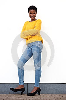 Full body beautiful young african american woman smiling against white wall