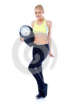 Full body of blond sporty woman holding scale