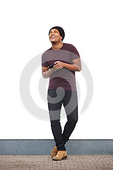 Full body happy african american man holding mobile phone and laughing