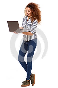 Full body happy woman against isolated white background holding laptop