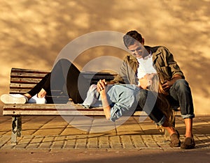 Full body happy woman and man in embrace on park bench
