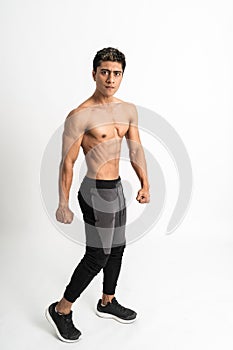 Full body image of asian young man showing a muscular side belly stand facing side