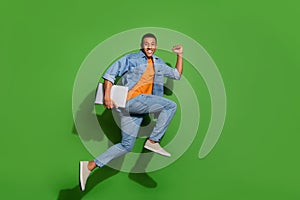 Full body image of energetic active young man running to office deadline time isolated on green color background