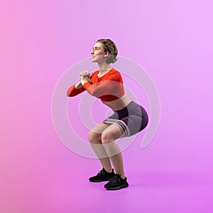 Full body length gaiety shot athletic sporty woman with kicking position posture