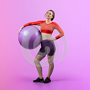 Full body length gaiety shot athletic and sporty young woman with fitness ball