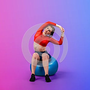 Full body length gaiety shot athletic and sporty young woman with fitness ball